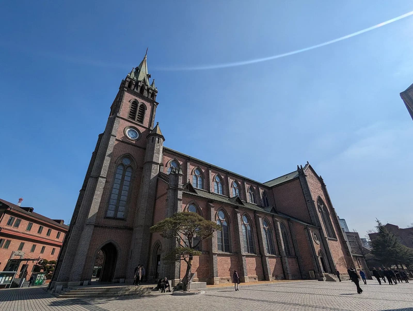 Catedral de Myeongdong en Seúl, templo neogótico de ladrillo rojo con su torre, bajo cielo azul