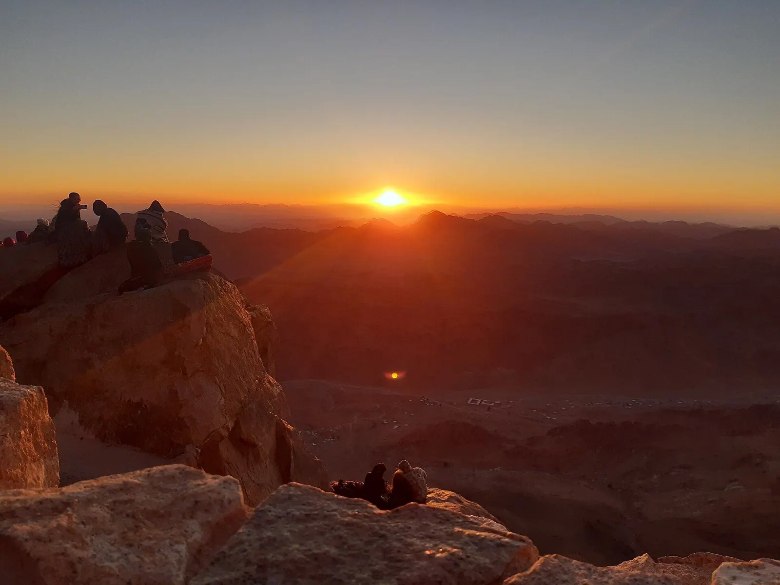 Amanecer desde la cima del Monte Sinaí, con el sol naciendo sobre las montañas del desierto